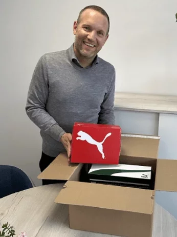 Mann packt Puma - Schuhkartons  aus