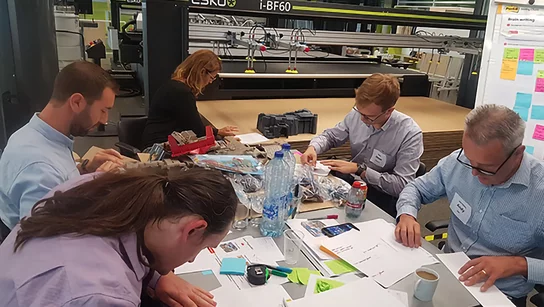 Gruppe von arbeitenden Mitarbeitern an einem Tisch 