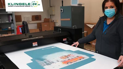 Mitarbeiterin vor einem bedrucktem Papier