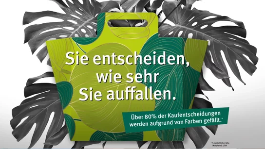 grüne Tragetasche mit Pflanzen im Hintergrund 
