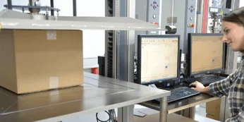 A woman squeezing a package tightly with a machine A woman squeezing a package tightly with a machine