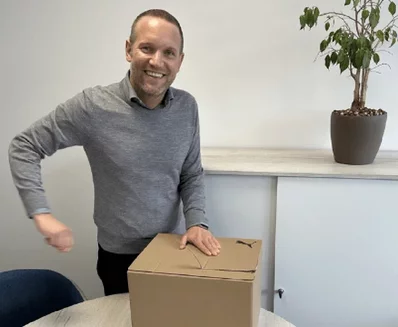 Faltboden-Verpackung wird von einem Mann geöffnet 