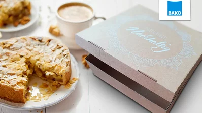Tortenverpackung für die BÄKO, daneben ein Kaffee und ein Kuchen Tortenverpackung für die BÄKO, daneben ein Kaffee und ein Kuchen